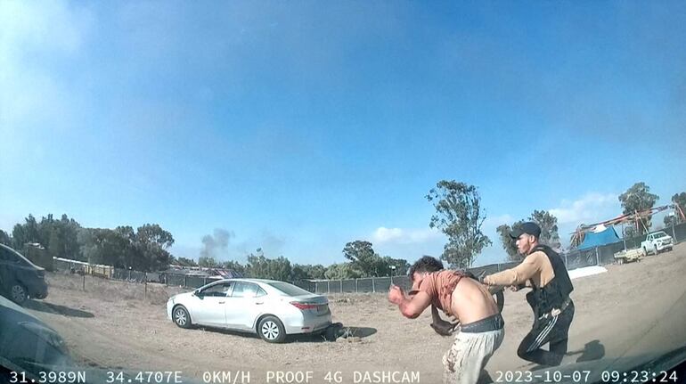 Esta captura de un video posteado en Telegram muestra a un palestino armado llevándose a un asistente del festival musical Supernova cerca del kibutz Reim en el desierto de Negev.