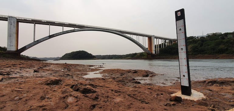 Puente de la Amistad sin personas, sobre un río con escaso nivel de agua y cielo nublado.