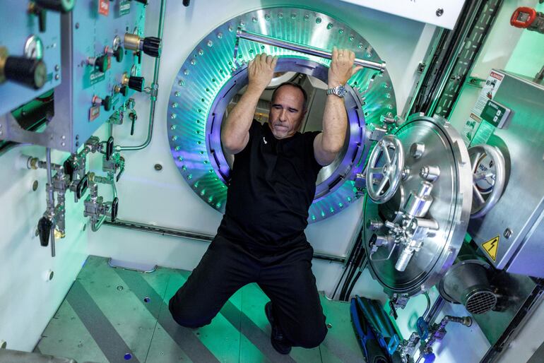 Roger Garcia, director de Operaciones del Hábitat, pasa a través de una escotilla dentro del hábitat submarino humano piloto Vanguard DEEP, exhibido en un almacén en Miami, Florida, Estados Unidos, el 29 de octubre de 2025.