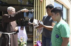 El hermano capuchino Antonio Carlos Lemhkuhl bendice a la mascota de una familia, en el Convento San Pío de Pietrelcina del barrio Trinidad de Asunción.