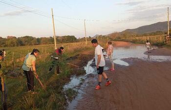 Vecinos de la compañía Potrerito, con azadas en mano, salen a reparar el camino rural en Acahay.