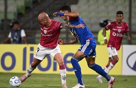 El delantero paraguayo del Independiente del Valle, Carlos González, y el defensa de Universidad Central, Williams Velásquez, luchan por el balón durante el partido de fútbol de la fase de grupos de la Copa Libertadores entre el Universidad Central de Venezuela y el Independiente del Valle de Ecuador en el estadio Olímpico de la UCV en Caracas