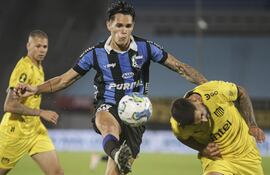 Rubén Bentancourt (c), autor de un un gol para Liverpool, disputa el balón con Maximiliano Olivera, de Peñarol. durante el partido final.