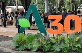 Multitud en evento al aire libre con decoraciones en verde y naranja, personas en ropa casual y formal.