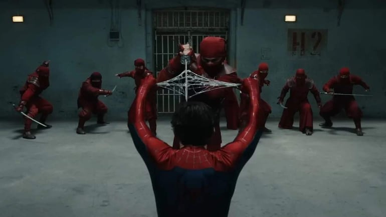 Hombre de pie con una espada, en un ambiente de presentación de Spider-Man, con luces y decoración temática.