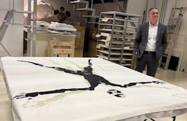 El coleccionista Daniel Mendonca posa junto al "Sudario" de Osvaldo Salerno que fue donado a la Colección Malba.