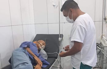 El enfermero Fredi Mendez Portillo atiende a un paciente de edad avanzada en un hospital de Río Verde.