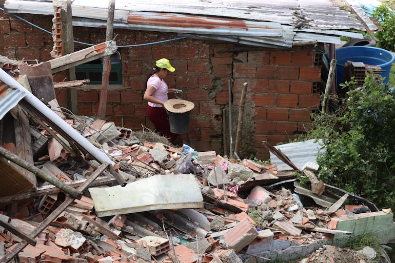 Una mujer camina entre escombros causados por los terremotos en El Junquito (Venezuela). 