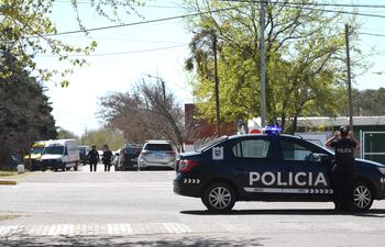 Agentes de la policía custodian a las afueras de un colegio este miércoles, en Mendoza (Argentina). Una adolescente de 14 años ingresó con un arma este jueves a un colegio de la provincia argentina de Mendoza, efectuó tres disparos y se atrincheró en el interior, sin que por el momento se hayan reportado heridos. EFE/ STR