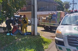 Bomberos asisten a una de las víctimas del asalto a repartidores de Lactolanda en Lambaré.