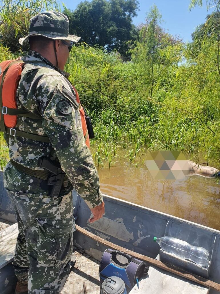 Hallazgo del cuerpo del pescador desaparecido en el río Paraguay. Un militar lo observa minutos antes de sacarlo del agua. (Gentileza).