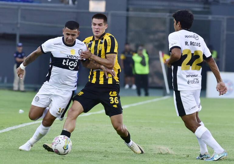 Derlis González (i), jugador de Olimpia, disputa el balón con Luis Martínez, futbolista de Guaraní, en un partido de la primera fecha del torneo Apertura 2025 del fútbol paraguayo en el estadio Defensores del Chaco, en Asunción, Paraguay. 