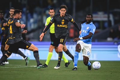 El volante italiano de la Roma, Niccolò Pisilli intenta meter el pase ante la presencia cercana del mediocampista camerunés del Nápoles Frank Anguissa.