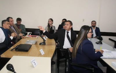 Miguel Prieto gesticula en sala, acompañado de defensores en trajes oscuros y visibles expresiones de preocupación.