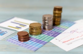 Imagen de monedas sobre gráficos financieros.