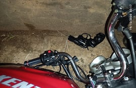 La motocicleta y el arma que habría sido utilizado por los presuntos delincuentes.