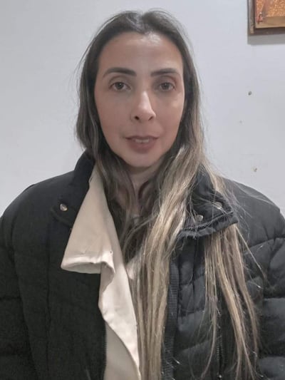 Juana Carolina Vera con cabello lacio y chaqueta negra, mirando a la cámara en una sala con pared blanca.