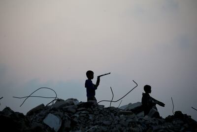 Niños palestinos desplazados se encuentran sobre los escombros de edificios destruidos durante el bombardeo israelí de Gaza, al atardecer sobre el campo de refugiados de Bureij, en el centro de la Franja de Gaza, el 10 de noviembre de 2025.