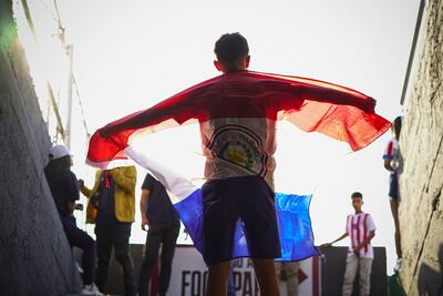 Un niño con la bandera de Paraguay ingresando al estadio Defensores del Chaco para el partido frente a Argentina por las Eliminatorias Sudamericanas 2026.