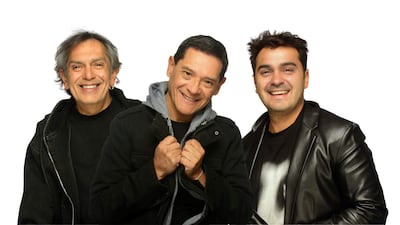 Los Nocheros sonríen luciendo abrigos y chaquetas, en un retrato frontal armonioso sobre fondo blanco.