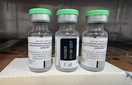 Tres frascos de vidrio con tapa verde, etiquetados como GARDASIL™, sobre fondo blanco.