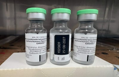 Tres frascos de vidrio con tapa verde, etiquetados como GARDASIL™, sobre fondo blanco.