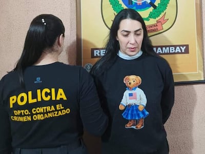 Dos mujeres en oficina del Departamento Contra el Crimen Organizado, una lleva camiseta policial y otra un suéter negro con un diseño de oso.