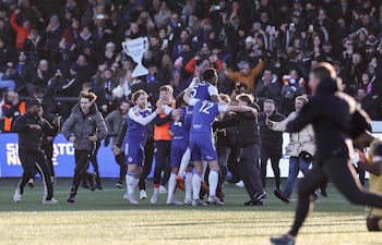 Los aficionados del Macclesfield invaden el campo para celebrar la victoria del equipo con los jugadores (centro) al finalizar el partido de fútbol de la tercera ronda de la FA Cup inglesa entre el Macclesfield Town y el Crystal Palace, en el estadio Leasing.com Stadium, Moss Rose, en Macclesfield, al norte de Inglaterra