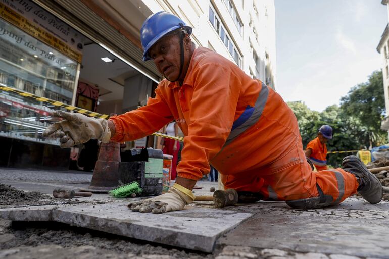 Fotografía del obrero Juarez Pereira, de 67 años de edad mientras trabaja en la renovación de una calle el 23 de abril de 2024 en el centro de São Paulo (Brasil).