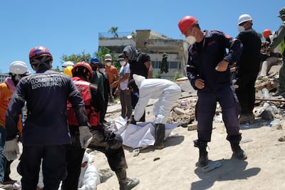 Bomberos y voluntarios rescatan un cuerpo sin vida durante los trabajos de remoción de escombros de los edificios Mision Vivienda OPPE luego del doble terremoto de magnitud 7,2 y 7,5 ocurrido el pasado 24 de Junio, este martes en La Guaira (Venezuela).