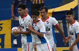 El defensor de Nacional, Gastón Benítez, felicitado por sus compañeros Alexis Cañete, Roque Santa Cruz e Hugo Iván Valdez, tras anotar el tanto del empate transitorio frente al Sportivo Luqueño.