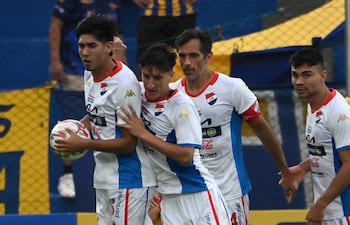 El defensor de Nacional, Gastón Benítez, felicitado por sus compañeros Alexis Cañete, Roque Santa Cruz e Hugo Iván Valdez, tras anotar el tanto del empate transitorio frente al Sportivo Luqueño.