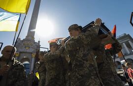 Los camaradas de los fallecidos militares ucranianos Serhii Konoval y Taras Petryshyn llevan sus ataúdes durante una ceremonia de despedida en la Plaza de la Independencia (Maidan Nezalezhnosti) en Kiev, Ucrania.