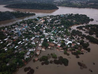 Vista aérea de Barrio San Rafael con casas parcialmente sumergidas y vegetación alrededor en medio de inundaciones.