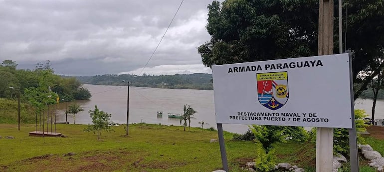 Cartel de 'ARMADA PARAGUAYA' en un paisaje natural alrededor del río Paraná, con vegetación densa y cielo nublado.