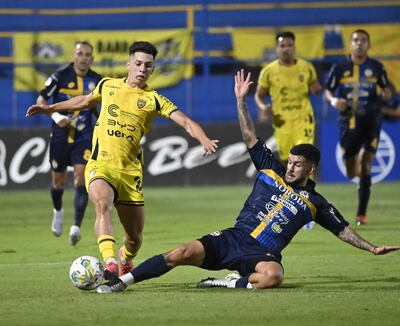 El recio zaguero uruguayo Agustín da Silveira (24 años), del Sportivo Trinidense, hace un esfuerzo para cortar la rauda marcha ofensiva del recoletano Thiago Constantino Emmanuel Vidal Obregón (22), quien en 2023 compitió en la Copa Sudamericana con Tacuary.