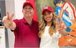 Camilo Pérez López Moreira y Violeta Fornerón sonríen mientras hacen la señal de la paz, en un despacho con una bandera roja.