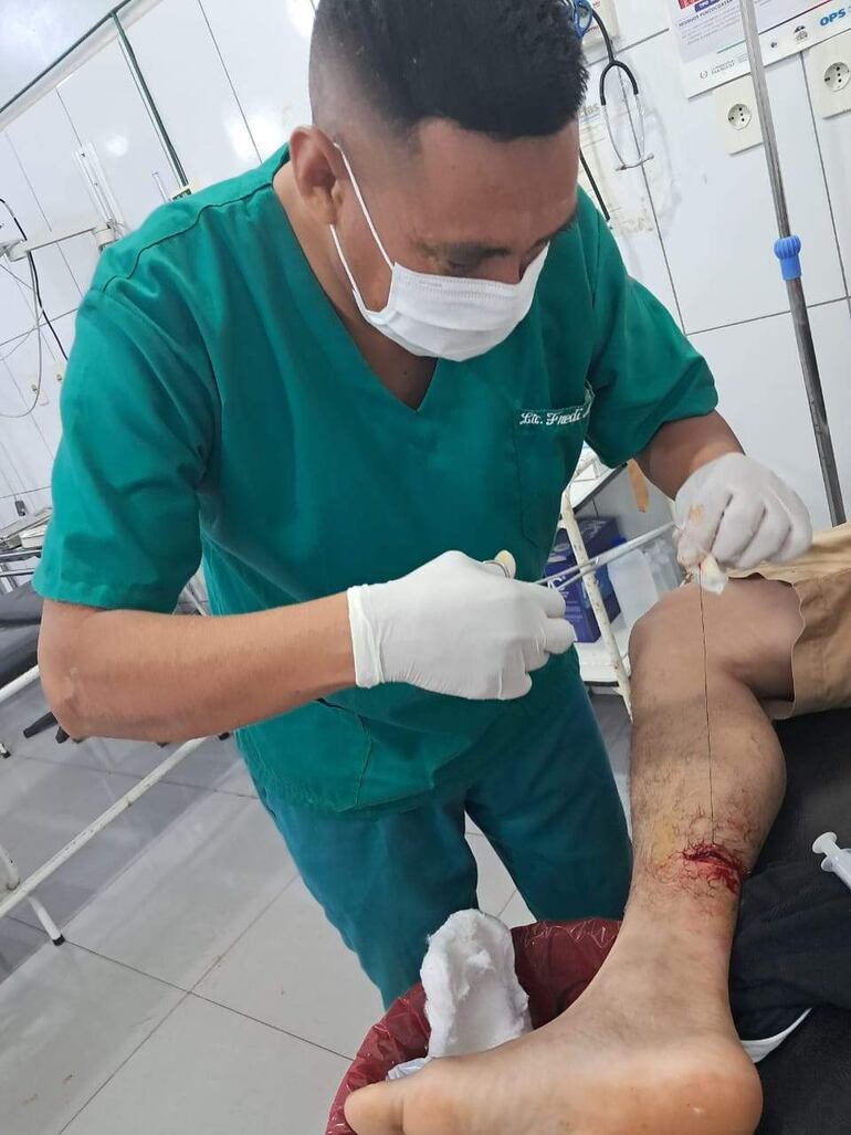 El enfermero Fredi Mendez Portillo realiza un procedimiento médico en una herida de un paciente en Río Verde.