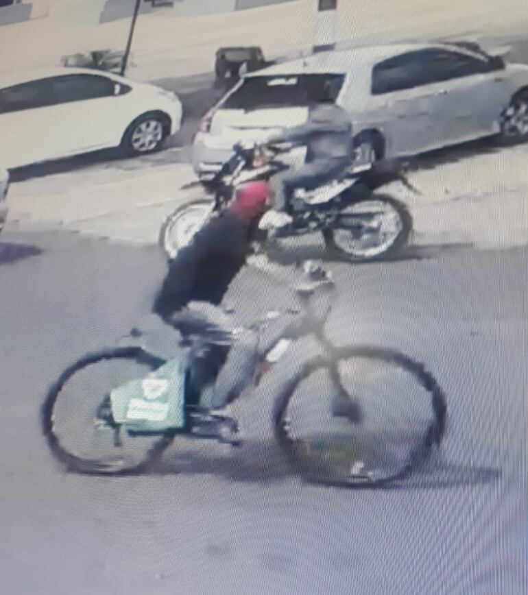 Momento en que el ladrón se retiraba de la farmacia en la bicicleta eléctrica robada y con una máscara de Spiderman. (Captura de vídeo).