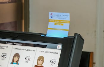 Una papeleta de votación (de capacitación) en la ranura de la máquina de voto. (Foto: TSJE)