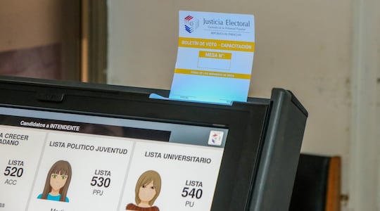 Una papeleta de votación (de capacitación) en la ranura de la máquina de voto. (Foto: TSJE)