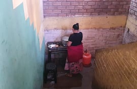 La cocinera de la escuela prepara el almuerzo en la escalera de la Escuela Onorio Takachi.