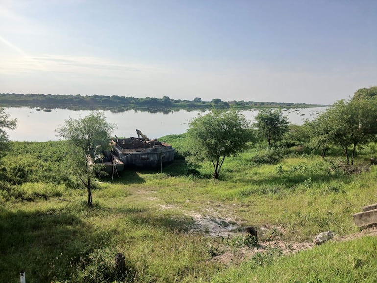 Paisaje natural con un barco en la orilla del río Paraguay rodeado de densa vegetación verde.
