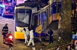 Equipos de emergencia evacuan una bolsa para cadáveres en el lugar del descarrilamiento de un tranvía en Milán el 27 de febrero de 2026.