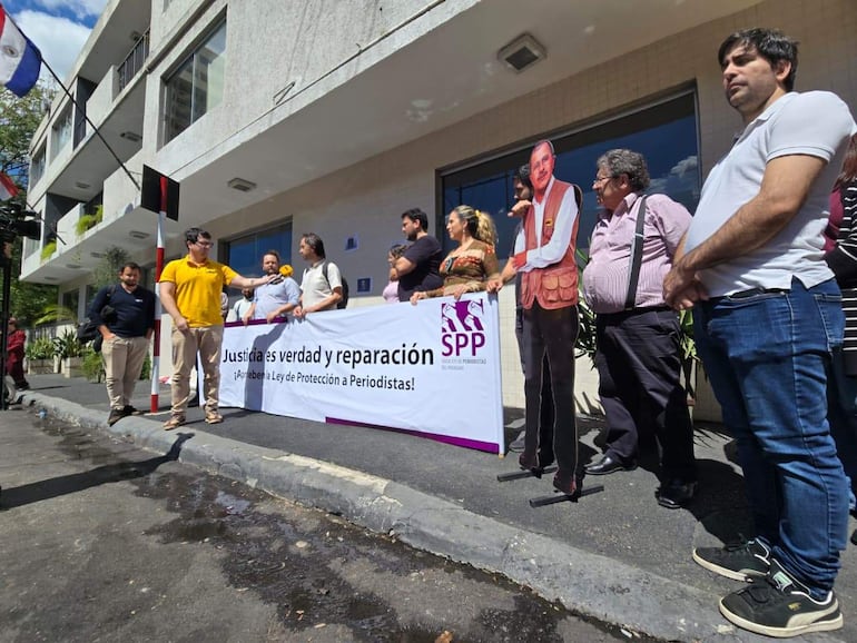 Un grupo de seis personas en manifestación, con pancarta que dice 'Justicia es verdad y reparación'.