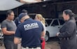 Luis Alberto Quintana Acosta en taller mecánico con un policía y dos mujeres en conversación.