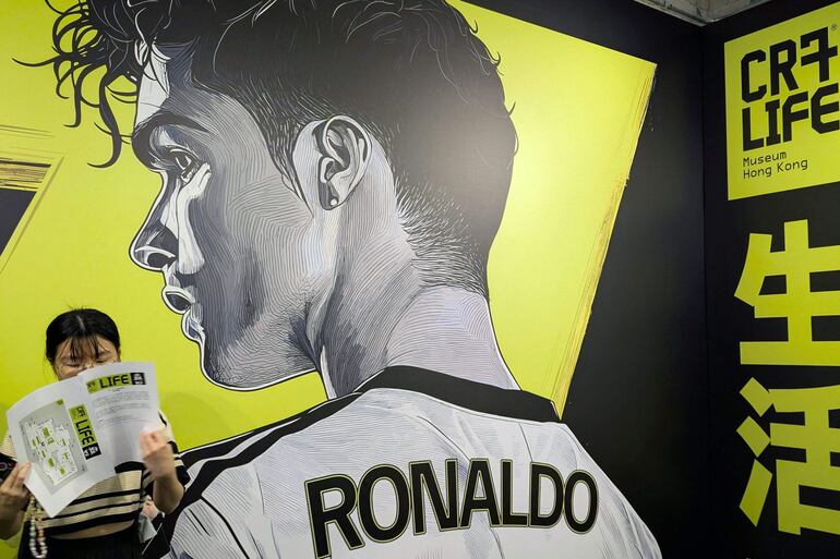 Un visitante (izq.) observa un gran mural del futbolista Cristiano Ronaldo durante la inauguración del Museo CR7 LIFE en Hong Kong.