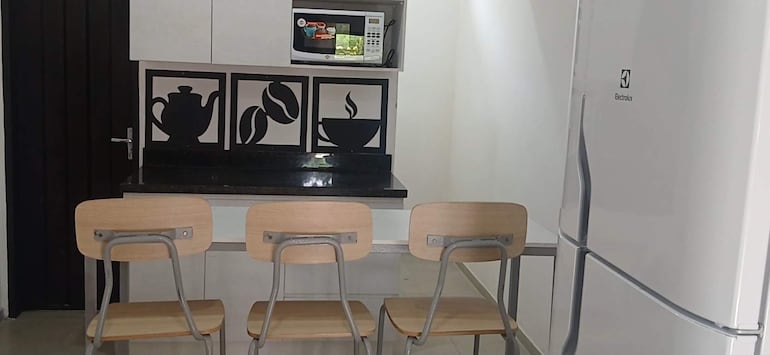 Espacio interior moderno con mesa y sillas vacías, decoraciones relacionadas con café y electrodomésticos Electrolux.