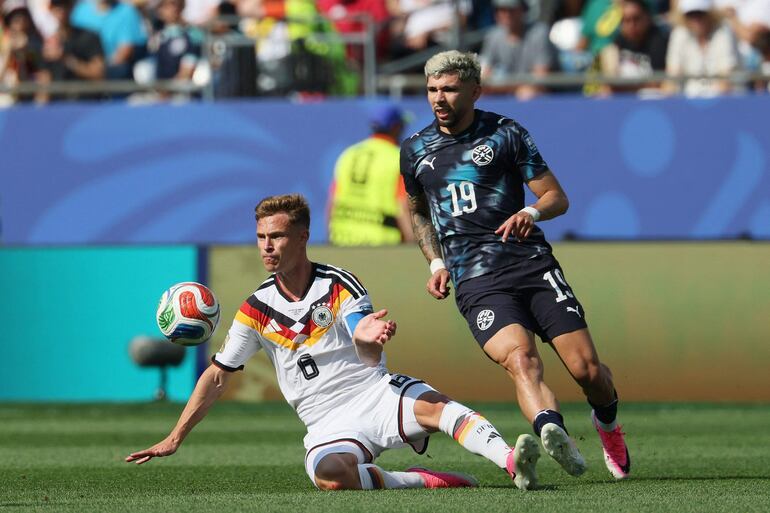 El defensa de Alemania Joshua Kimmich y el centrocampista de Paraguay Julio Enciso luchan por el balón durante el partido de fútbol de los dieciseisavos de final de la Copa del Mundo 2026 entre Alemania y Paraguay en el Boston Stadium en Foxborough.