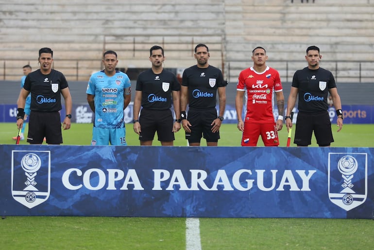 Los capitanes de ambos equipos posan junto al árbitro y sus asistentes antes del comienzo del partido.